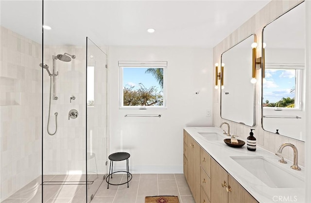 full bath featuring tile patterned flooring, a sink, and tiled shower