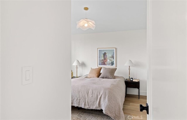 bedroom featuring light wood-style flooring and baseboards