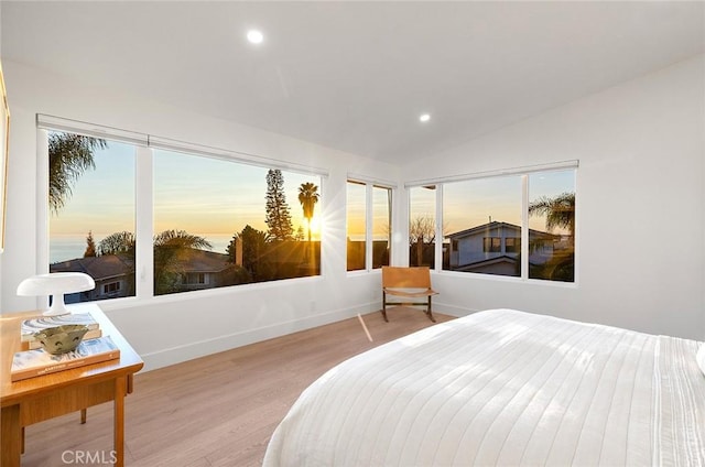 bedroom with light wood-type flooring, vaulted ceiling, baseboards, and recessed lighting