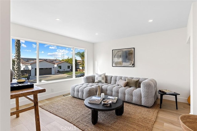 living room with recessed lighting, baseboards, a residential view, and light wood finished floors