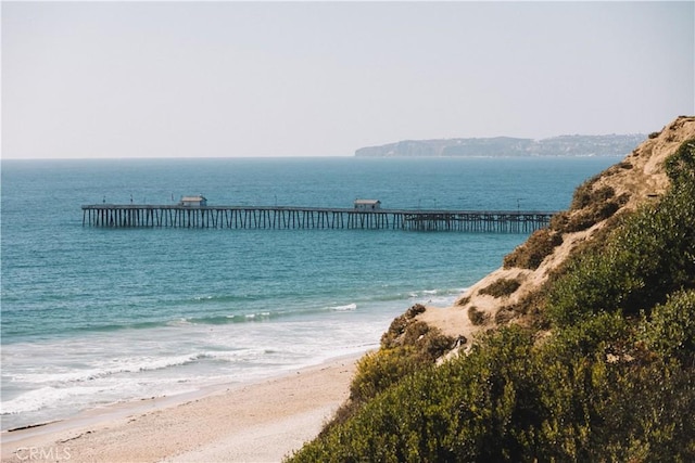 property view of water with a pier and a beach view