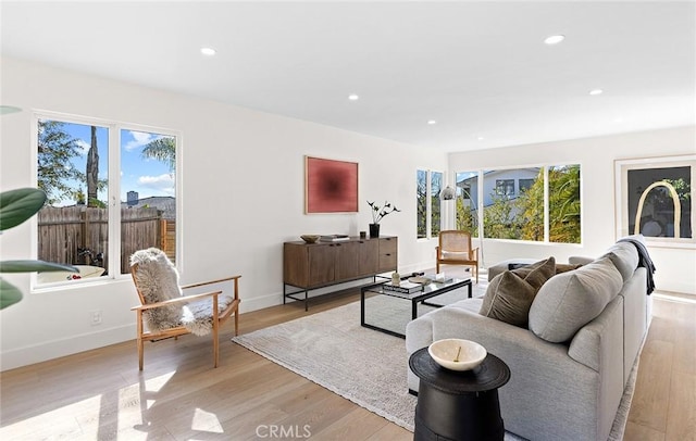 living room featuring light wood-style flooring, baseboards, and recessed lighting