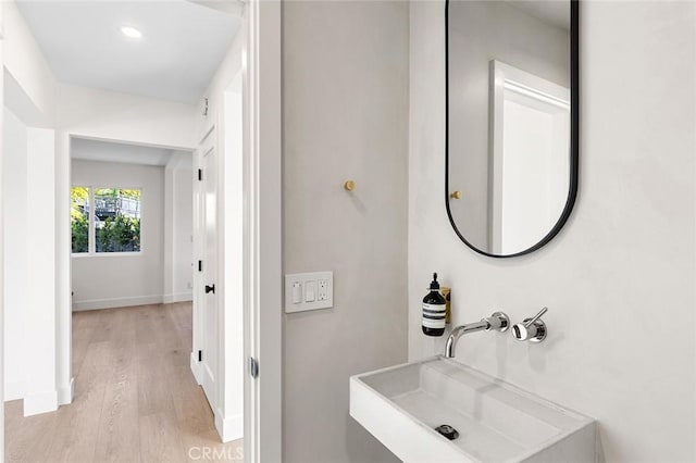 bathroom with baseboards, a sink, and wood finished floors