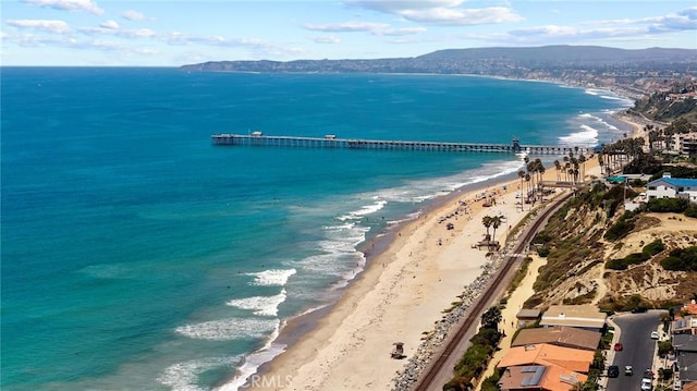 birds eye view of property featuring a view of the beach and a water and mountain view