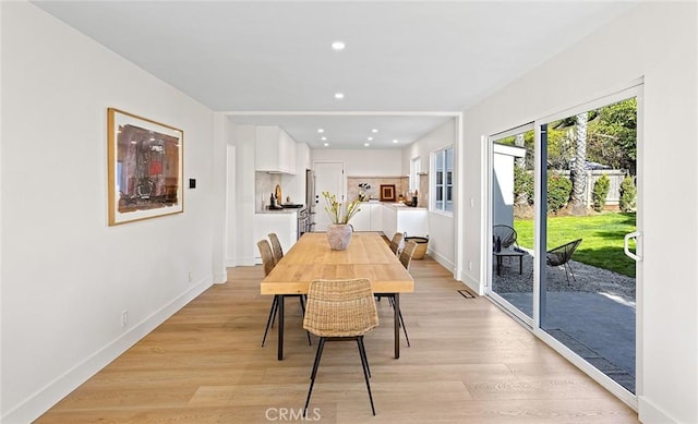 dining area featuring baseboards, light wood-style flooring, and recessed lighting