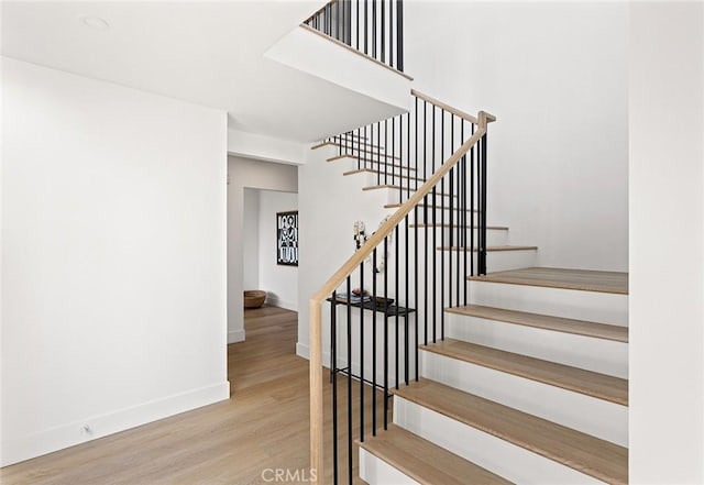 stairway featuring wood finished floors and baseboards