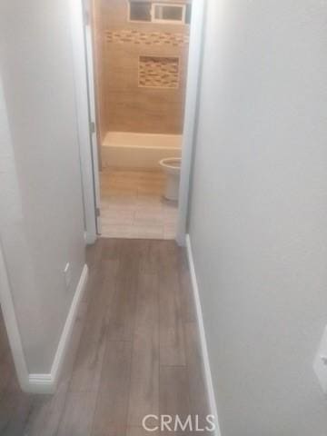 corridor featuring dark wood-style floors and baseboards