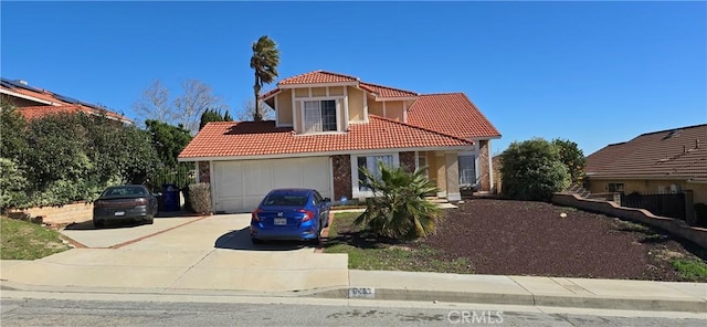 mediterranean / spanish-style home featuring a garage, concrete driveway, and a tiled roof