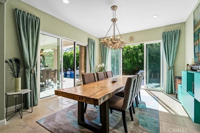 dining room with an inviting chandelier, stone tile flooring, recessed lighting, and baseboards