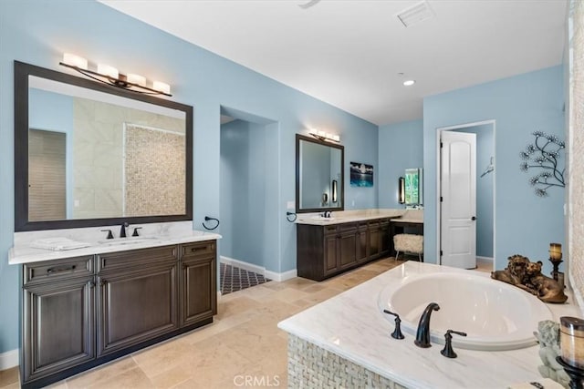 bathroom featuring a garden tub, two vanities, a sink, and baseboards