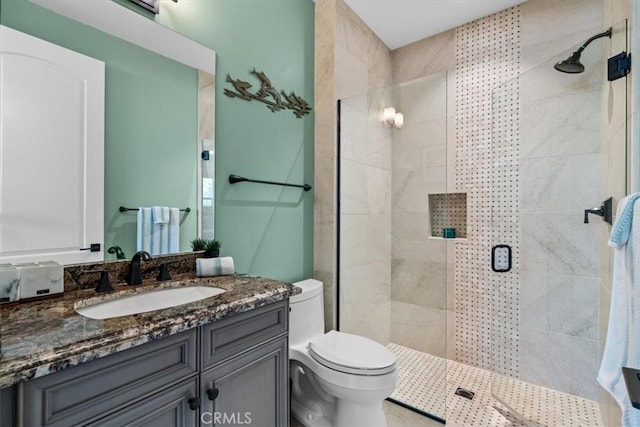 bathroom with vanity, toilet, and a stall shower