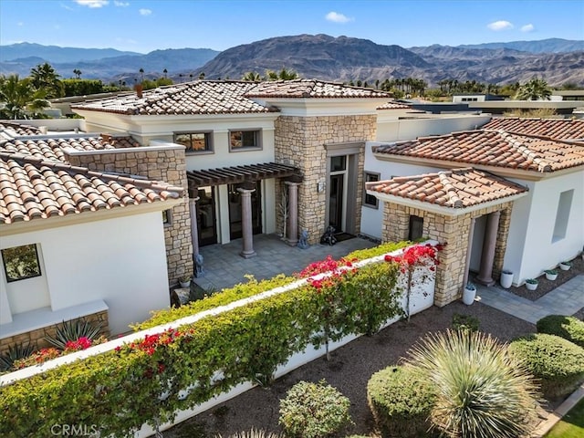 mediterranean / spanish-style house featuring a patio, a mountain view, a tiled roof, stucco siding, and a pergola