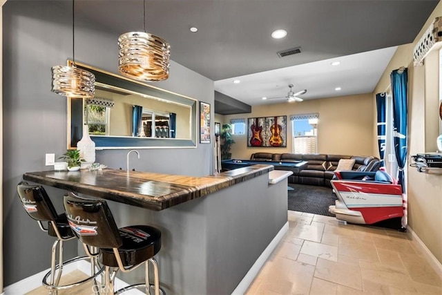 bar featuring visible vents, baseboards, recessed lighting, a ceiling fan, and wet bar
