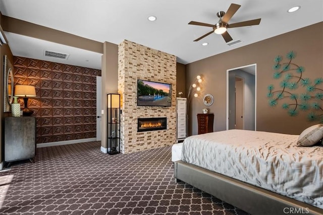 bedroom featuring dark colored carpet, visible vents, a fireplace, and recessed lighting
