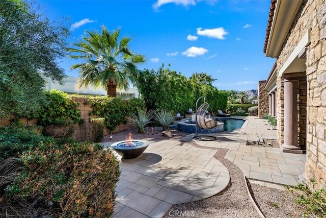 view of patio featuring an outdoor fire pit, fence, and a fenced in pool