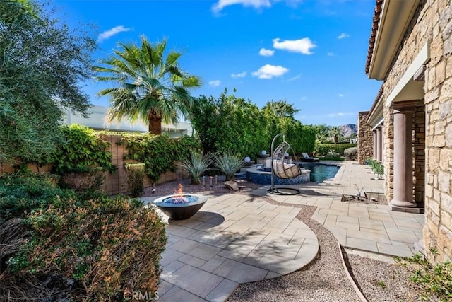 view of patio featuring a fire pit and a fenced in pool