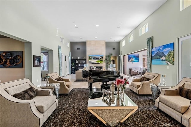 living area with visible vents, a towering ceiling, and recessed lighting