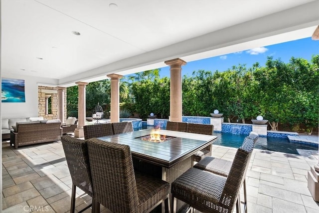 view of patio / terrace featuring an outdoor living space with a fire pit and an outdoor pool