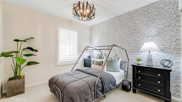 bedroom with an accent wall, light carpet, a notable chandelier, and baseboards