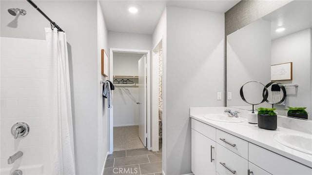 bathroom featuring shower / tub combo with curtain, a sink, a spacious closet, and double vanity