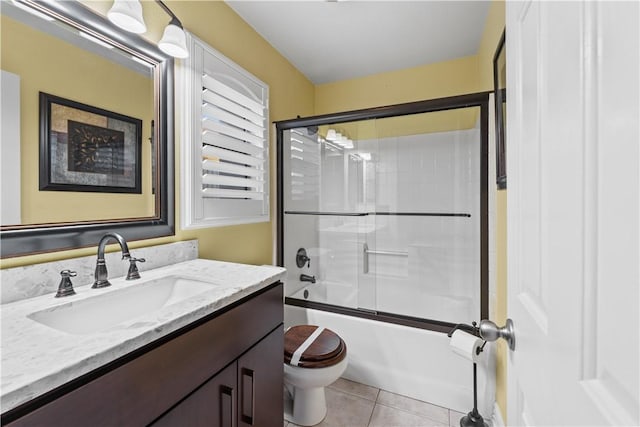 full bathroom with tile patterned flooring, combined bath / shower with glass door, vanity, and toilet