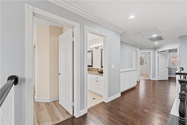 corridor featuring recessed lighting, wood finished floors, visible vents, attic access, and crown molding