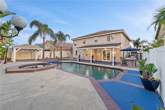 view of pool with a patio area, a fenced backyard, a pool with connected hot tub, and a gazebo