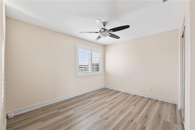 empty room featuring light wood-type flooring, a ceiling fan, and baseboards