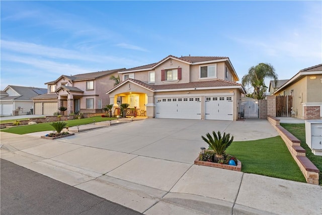 traditional-style house featuring a garage, a tile roof, a gate, fence, and stucco siding