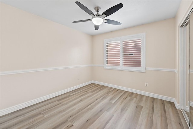 empty room featuring light wood-type flooring, baseboards, and a ceiling fan