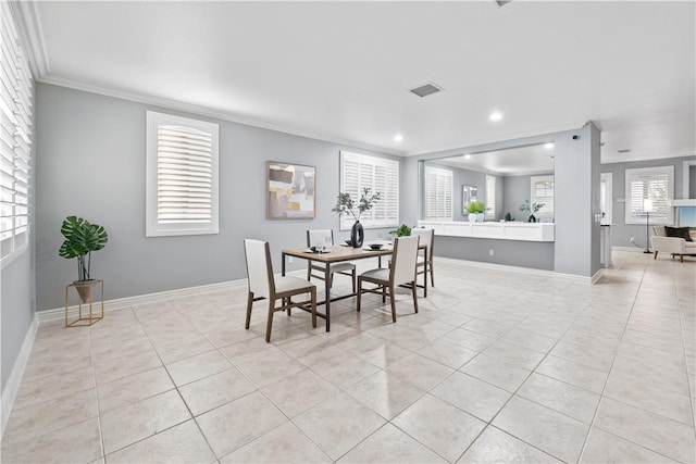 dining space with ornamental molding, light tile patterned flooring, visible vents, and baseboards