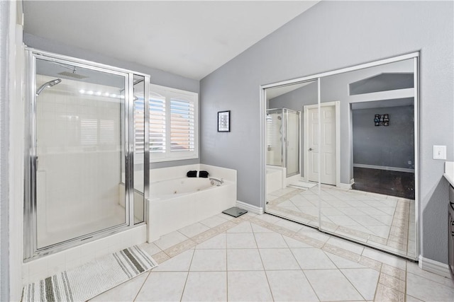 bathroom with vanity, baseboards, vaulted ceiling, a bath, and tile patterned floors