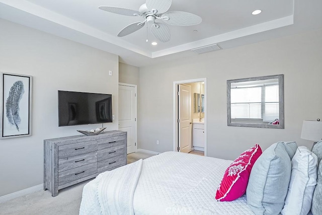 bedroom with light colored carpet, baseboards, a raised ceiling, and recessed lighting