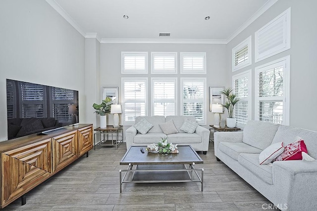 living room with visible vents, crown molding, and wood finished floors