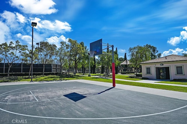 view of sport court with community basketball court, a lawn, and fence