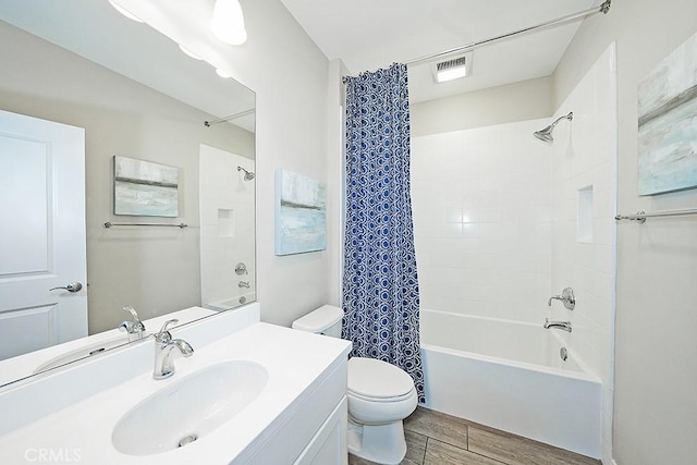 bathroom featuring shower / bath combo, visible vents, toilet, wood tiled floor, and vanity