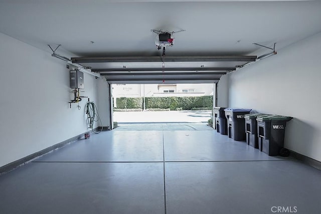 garage featuring a garage door opener and baseboards