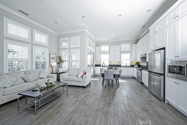 living room featuring crown molding, visible vents, and dark wood finished floors