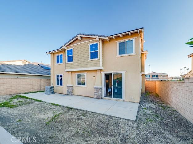 rear view of house featuring cooling unit, a patio area, a fenced backyard, and stucco siding