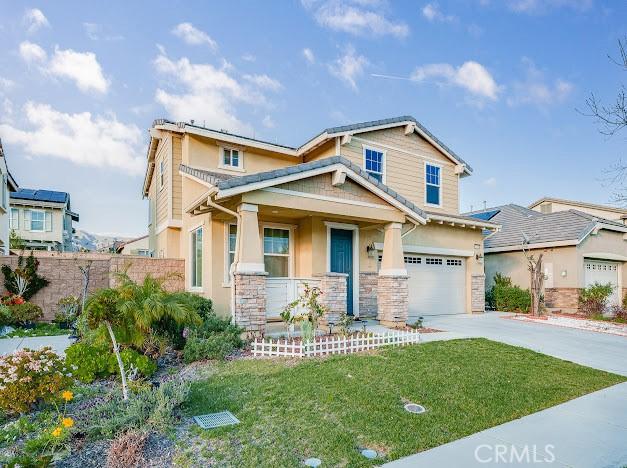 craftsman-style house with covered porch, an attached garage, a front yard, stone siding, and driveway