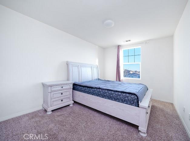 bedroom featuring baseboards and light colored carpet