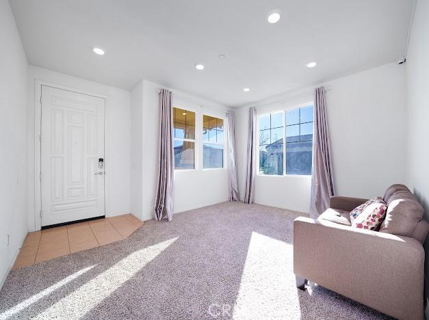 living area featuring light carpet, light tile patterned flooring, and recessed lighting