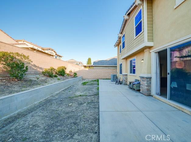 exterior space featuring a fenced backyard and central AC unit