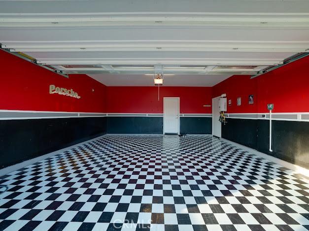 garage with a wainscoted wall and a garage door opener