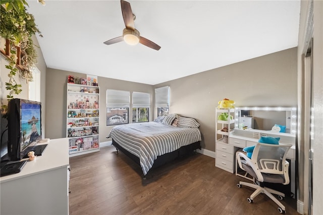 bedroom with a ceiling fan, baseboards, and dark wood-style flooring