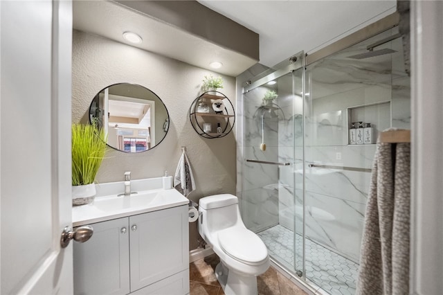 full bath with toilet, a textured wall, a marble finish shower, and vanity