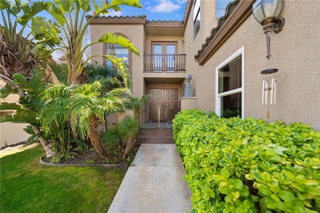 entrance to property with a tiled roof and stucco siding