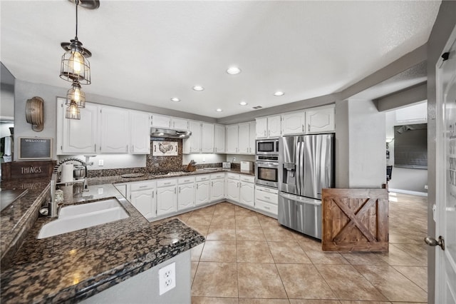 kitchen featuring appliances with stainless steel finishes, a sink, white cabinetry, and pendant lighting