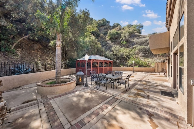 view of patio / terrace featuring fence, outdoor dining area, and a gazebo