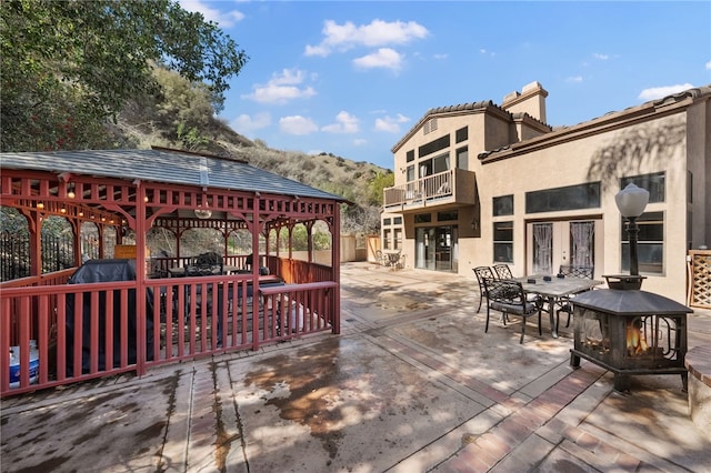 view of patio with a gazebo, an outdoor fire pit, and a mountain view